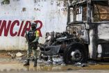Militar resguardando la zona en calles de Acapulco donde fue quemado un autobús por delincuentes.