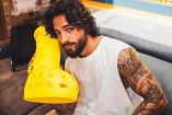 Maluma posando con sus botas amarillas