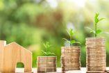 Casita de madera con tres montones de monedas de distintas alturas que representan crecimiento.