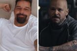 Ricky Martin acostado con playera blanca y Residente sentado en bar con jersey verde