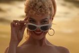 Margot Robbie sonriendo con lentes en película de Barbie
