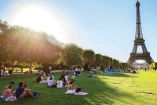Personas tratan de mitigar el calor en un parque cerca de la Torre Eiffel.