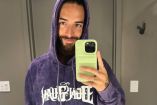 Maluma con sudadera morada tomando selfie en espejo
