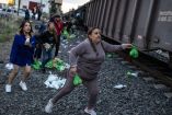 Mujeres y hombres muestran desesperación por entregar los víveres a los migrantes al paso del tren 