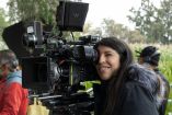 La directora filmando mira la pantalla de la enorme cámara de cine. 