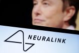 Musk detrás de una computadora en la que se lee neuralink