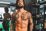 Maluma sin playera con cabello largo en gimnasio