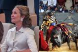 Infanta Elena sonriendo a lado de foto de torero