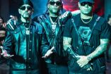 Don Omar abrazando a Wisin y Yandel vestidos de negro