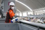 Un trabajador de la planta separa una botella de plástico del resto de la basura.