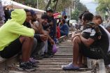 Migrantes esperan tren en vías de México.