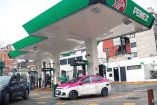 Taxi cargando gasolina en una estación de Pemex.