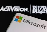 Logo de Microsoft en un celular y enfrente el de Activision Blizzard