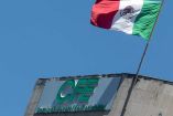 Logo de la CFE y una bandera de México en un edificio.