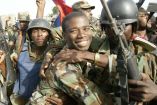 El comandante en jefe del Frente Revolucionario de Liberación Nacional de Haití, Guy Philippe, celebra con sus compañeros soldados en Cap-Haitien, Haití, el 22 de febrero de 2004.