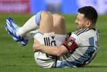 Lionel Messi tendido sobre el césped en un  partido de Argentina.