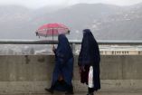 Mujeres con el velo caminando sobre un puente en una localidad de Afganistán. (AFP)