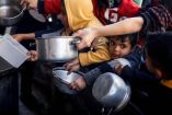 Niños palestino esperando a recibir comida. (Reuters)