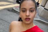 Rosalía con cabello recogido y vestido rojo en calle