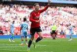 Scott McTominay celebrando apuntando al cielo.