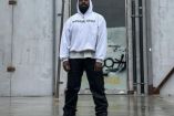 Kanye West con sudadera blanca, pantalón negro