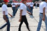 jovenes con gorras rojas marchando en servicio militar