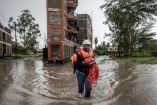 Miembros de la Cruz Roja de Kenia evalúan una zona afectada por las inundaciones mientras buscan residentes atrapados en sus casas tras las lluvias torrenciales.