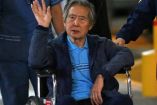 Expresidente Fujimori saludando sentado en una silla de ruedas.