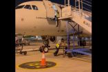 Empleado de aeropuerto cayendo de puesta de avión sin escalera