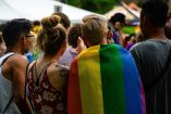 Jovenes con bandera LGBTQI+ en marcha