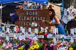 Una niña deposita flores en un monumento improvisado en la Escuela Primaria Robb en Uvalde, Texas, el 28 de mayo de 2022. Varias familias cuyos hijos murieron o resultaron heridos en un tiroteo masivo en su escuela de Texas hace dos años han demandado al fabricante de armas, así como a Instagram y la empresa de videojuegos Activision por comercializar el arma.