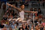Simone Biles saltando en un concurso de gimnasia.