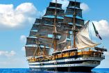 El buque escuela italiano Amerigo Vespucci, un navío de 101 metros de eslora y 15.5 metros de manga, navega con sus 26 velas desplegadas bajo un cielo azul claro. El navío, una joya de la armada italiana, está adornado con detalles dorados y lleva la bandera italiana ondeando en su popa.
