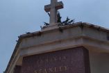 Vista de la cruz y la fachada de la cripta de la familia Stanley en el Panteón Español, destacando el nombre de la familia en letras doradas.