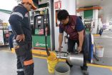 Trabajadores de gasolinera poniendo combustible en botes.