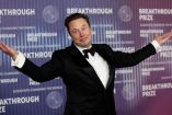 Elon Musk vestido con smoking feliz.