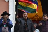 El presidente de Bolivia, Luis Arce (C), ondea una bandera boliviana en el balcón del Palacio de Gobierno en La Paz el 26 de junio de 2024.