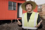 MrBeast con sombrero y casa roja regalada atrás
