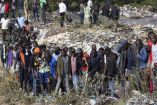 Personas mirando el basurero donde fueron encontradas mujeres desmembrados en Kenia.