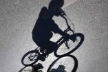 Sombra de un sujeto que viaja sobre una bicicleta por la calle