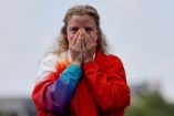 Julie Derron con ambas manos en el rostro después de conseguir su medalla en Triatlón