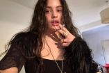 Rosalía fumando con blusa negra y cabello suelto