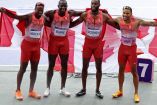 El equipo canadiense abrazado con su bandera en la espalda después de conseguir el oro en 4x100m