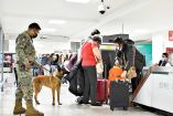 Militar y viajeros en un aeropuerto de México.