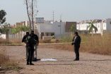 Elementos de la Policía de Investigación de Sinaloa parados en un lote baldío