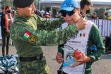 Militar de la SEDENA poniendo medalla a corredor