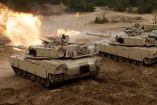 Tres tanques M1A1 Abrams en acción durante maniobras militares, con uno disparando su cañón principal. Estos modelos serán donados por Australia a Ucrania para apoyar sus fuerzas en la guerra contra Rusia.