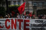 Integrantes de la CNTE con una manta en calles de México