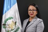 Retrato de Ligia Hernández, exsecretaria general adjunta del partido Semilla en Guatemala, frente a una bandera guatemalteca. La exfuncionaria, cercana al presidente Bernardo Arévalo, fue liberada luego de aceptar los cargos que le imputó la Fiscalía en un proceso de financiamiento irregular del partido. Su caso ha sido emblemático en la tensión entre el gobierno y la Fiscalía, liderada por Consuelo Porras. Hernández expresó que tomó esta decisión para proteger su vida y la de sus hijos, agradeciendo el apo