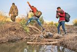 migrantes caminan tratanto de cruzar la frontera